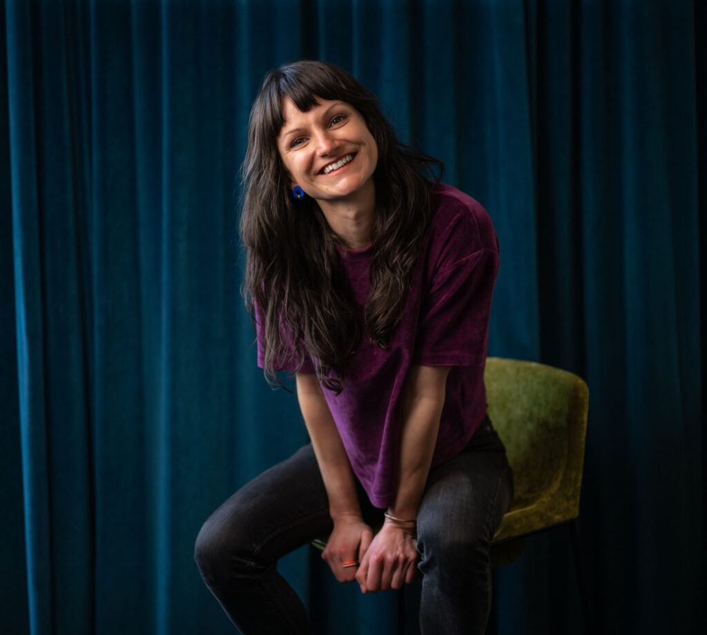 Frau sitzt auf einem Stuhl und lächelt